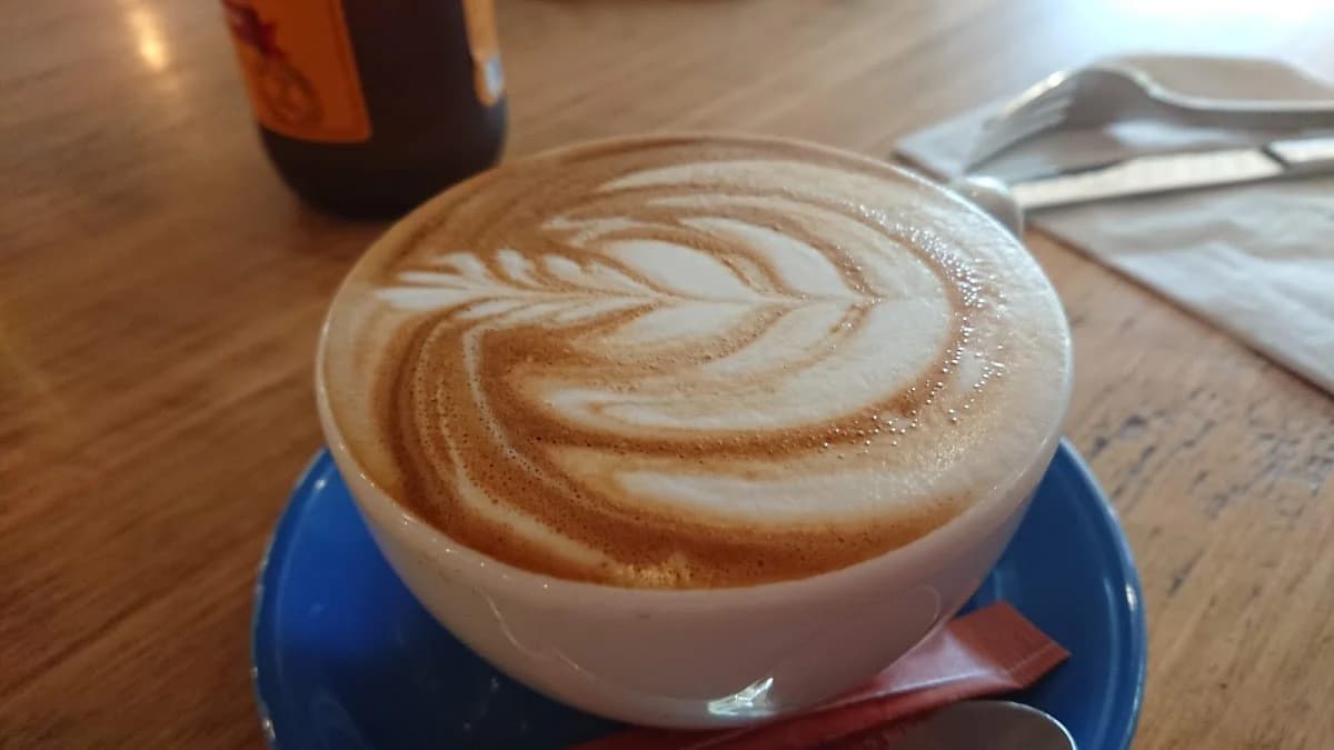A latte on a blue saucer at 1923